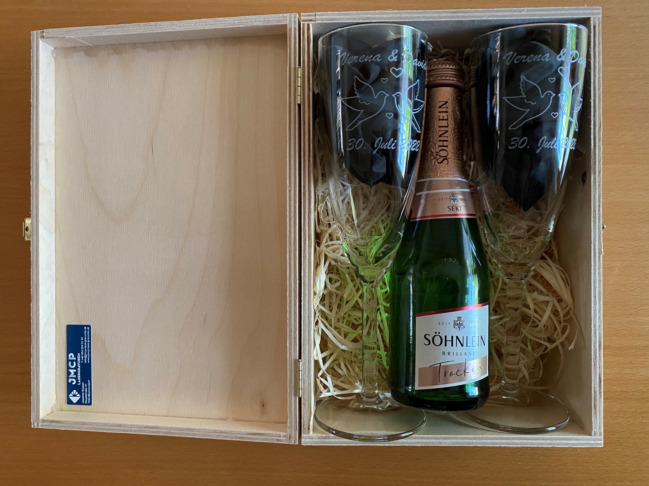 Geschenkbox mit Sektflasche und zwei gravierten Gläsern, ideal für Hochzeiten oder Jubiläen.