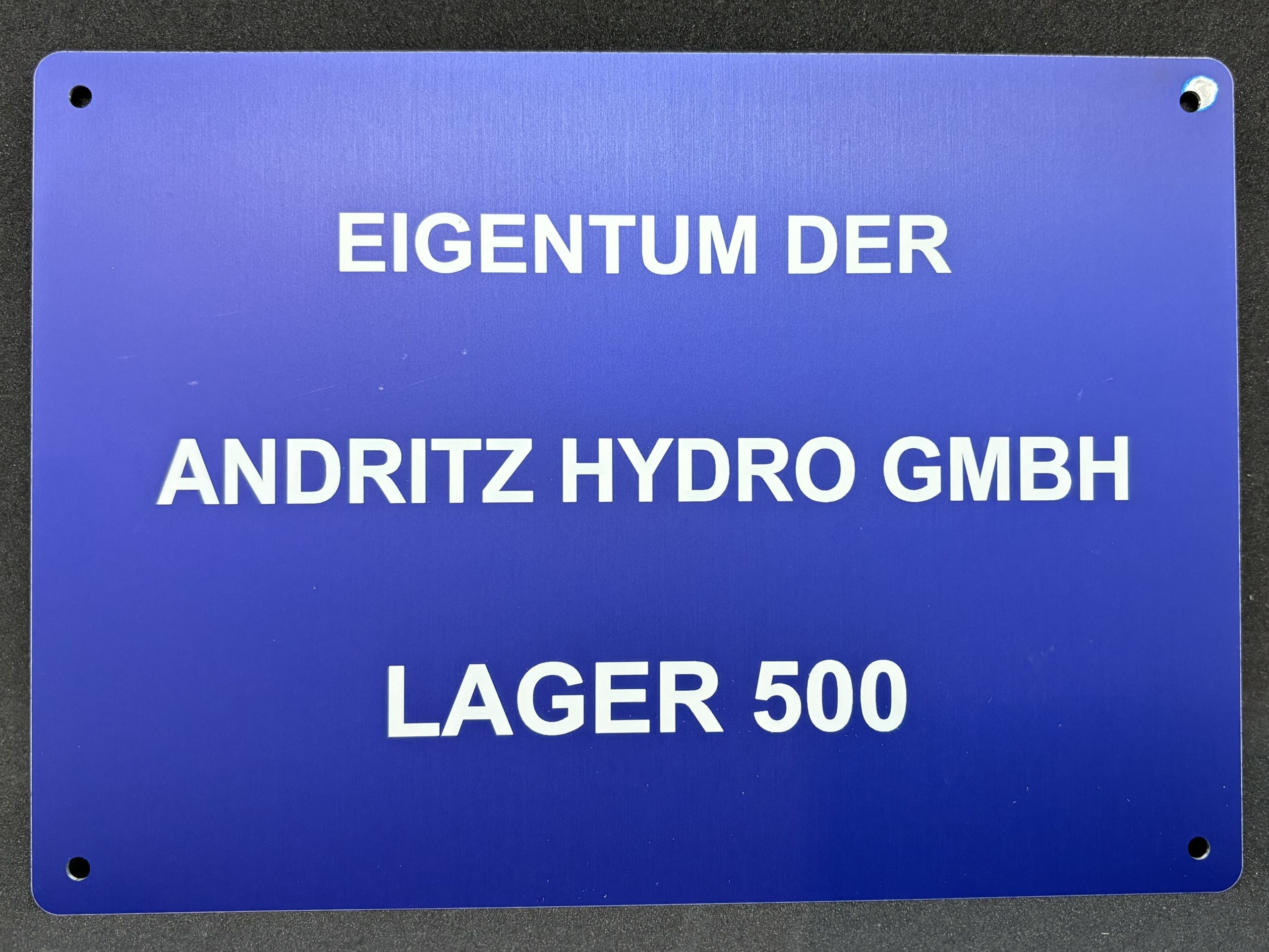 Blaues Schild mit der Aufschrift: Eigentum der Andritz Hydro GmbH, Lager 500.