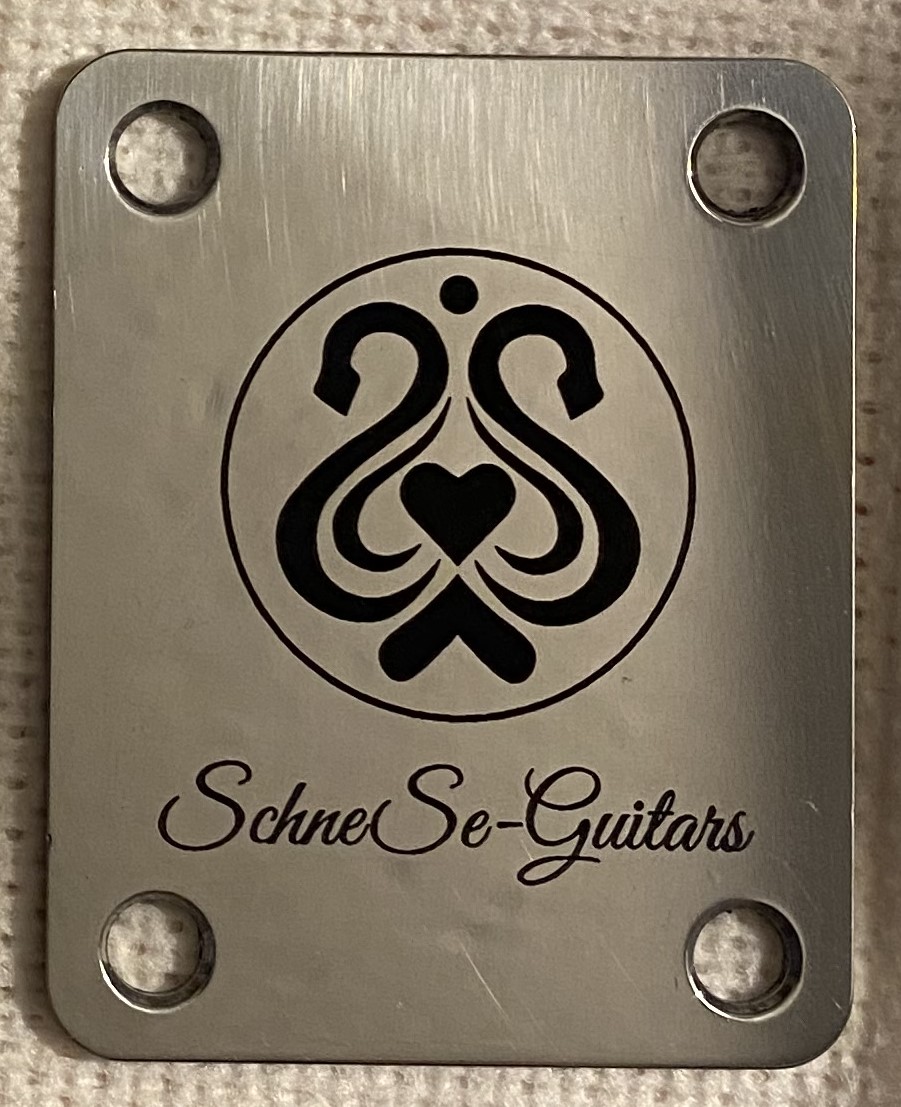 Metallplatte mit graviertem SchneSe-Guitars-Logo und stilisierten Schwänen, geeignet für E-Gitarren-Bausatz.